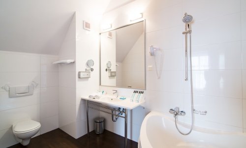 Czysta, biała łazienka hotelowa Hotelu Hanza to sanktuarium intymności, relaksu i gorących kąpieli
