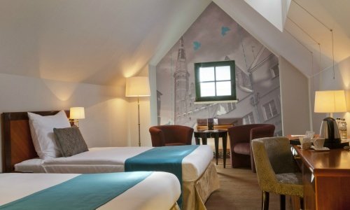 Przepiękny pokój twin z dwoma łóżkami na poddaszu z uroczym oknem i stolikiem kawowym w Hotelu Hanza
