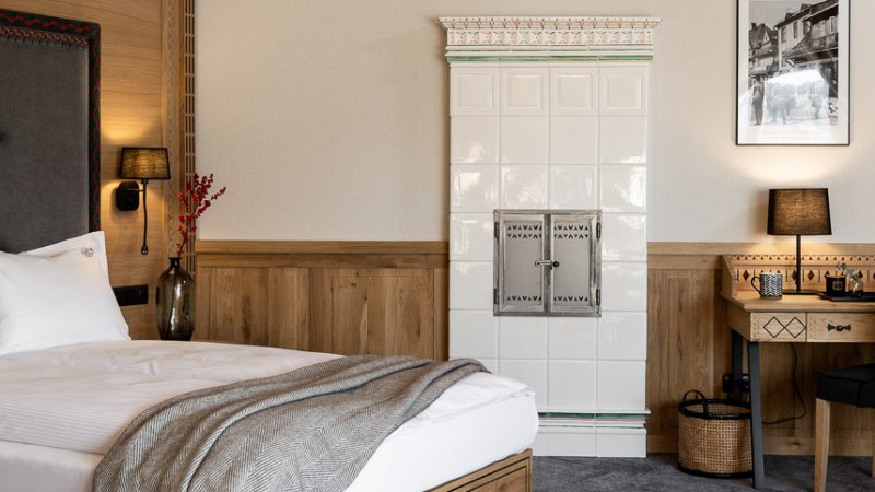 ręcznie ozdabiany kaflowy kominek, dębowe meble, wygodne łóżko, romantyczny hotel zakopane