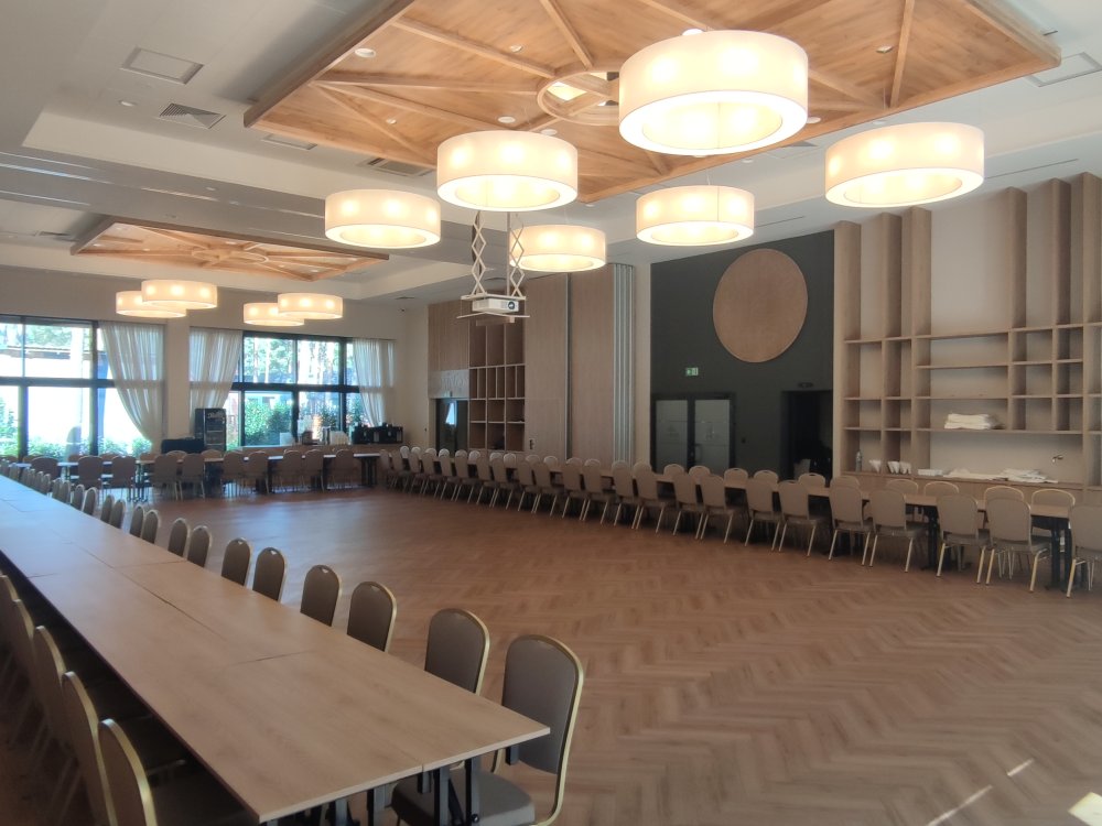 Przestronna sala Flauta z parkietem i długim stołem