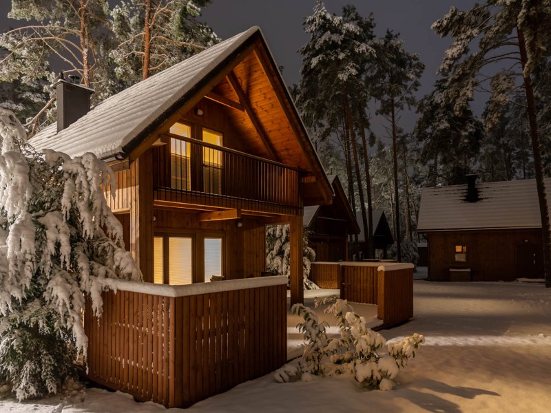 Ośnieżony domek Largo nocą z oświetlonym tarasem