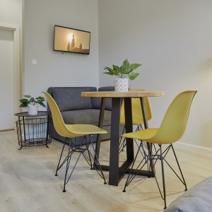 Prosty stolik z żółtymi krzesłami w loftowym stylu – elegancka i funkcjonalna aranżacja.