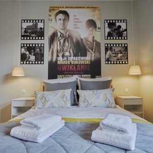 Dwuosobowe łóżko w apartamencie, starannie przygotowane z elegancką pościelą, gotowe na przyjęcie gości.