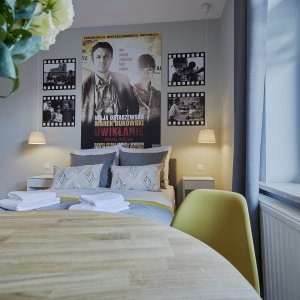 Plakaty filmowe ozdabiające ściany tematycznego apartamentu, dodające charakteru i atmosfery zgodnej z motywem przewodnim.