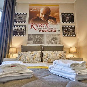 Stylowy apartament inspirowany filmem o papieżu, z unikalnymi plakatami filmowymi na ścianach.