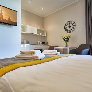 Wygodne łóżko dla dwóch osób w apartamencie w centrum Krakowa, przygotowane na komfortowy nocleg.