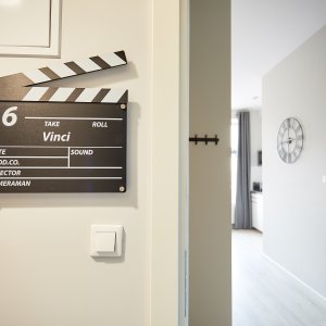  Klaps filmowy przy drzwiach, który wprowadza gości w filmowy klimat wnętrza