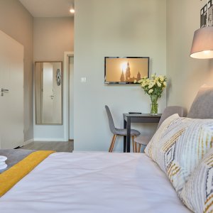  Widok z wygodnego łóżka w apartamencie, idealnym do relaksu po dniu pełnym atrakcji.