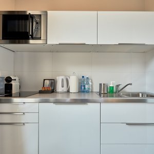 Nowoczesny aneks kuchenny z pełnym wyposażeniem, idealny do przygotowywania posiłków w apartamencie.