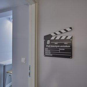 Wejście do apartamentu filmowego z dekoracyjnym klapsem filmowym