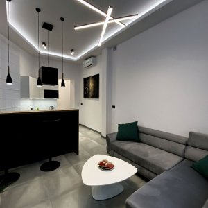 Nowoczesne wnętrze z designerskim oświetleniem sufitowym i funkcjonalnym narożnikiem