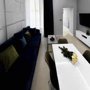 Przestronna strefa salonowa z dużym narożnikiem i eleganckim stołem jadalnianym