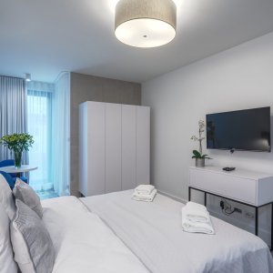 Przestronny apartament dla dwóch osób z nowoczesnym telewizorem, idealny do relaksu.