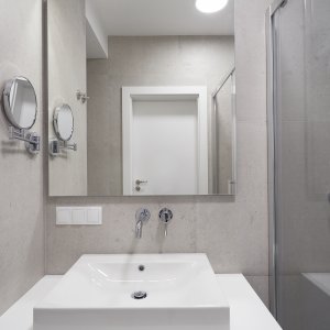 Przestronne lustro w łazience apartamentu w Krakowie, dodające elegancji i funkcjonalności