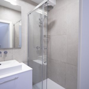 Minimalistyczna kabina prysznicowa w łazience apartamentu w Krakowie, funkcjonalna i elegancka