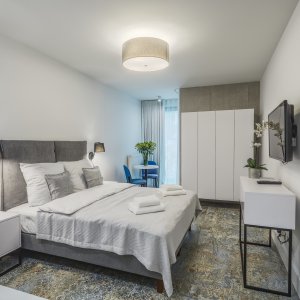 Elegancka i funkcjonalna aranżacja sypialni w apartamencie w Krakowie, z dbałością o detale