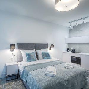 Jasny, przytulny apartament z dużym łóżkiem i aneksem kuchennym, idealny na romantyczny pobyt