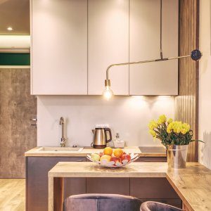 W pełni wyposażony aneks kuchenny z nowoczesnymi urządzeniami i jasnym wykończeniem.