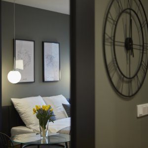 Zbliżenie na elegancki zegar ścienny w niebiesko-białym wnętrzu apartamentu.