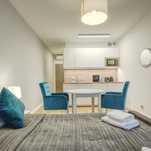 Przestronny widok na aneks kuchenny oraz jadalnię w apartamencie w Krakowie