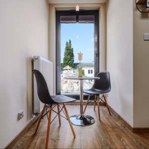 stolik i krzesła przy oknie w apartamencie z pięknym widokiem na Stare Miasto w Krakowie. Idealne na poranną kawę.