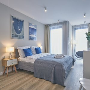 Eleganckie łóżko w centrum przestronnej sypialni, tworzące idealne miejsce do odpoczynku.