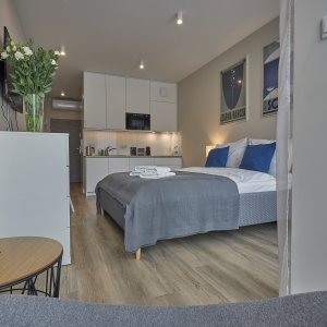 Łóżko z widokiem na zewnętrzny krajobraz, oświetlone naturalnym światłem z dużego okna.