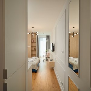 Elegancki korytarz prowadzący do przestronnych pomieszczeń, doskonale uzupełniający komfortowy nocleg w Krakowie.