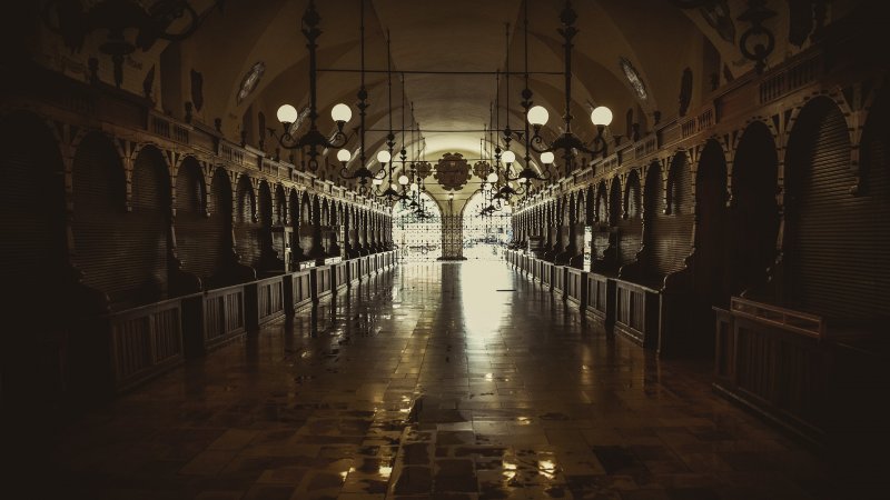  Wnętrze Sukiennic w Krakowie – zabytkowa hala targowa z misternie zdobionymi sklepieniami i stoiskami z rękodziełem.