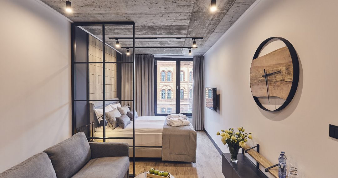 Pokój standard dla dwóch osób w 4-gwiazdkowym hotelu w Krakowie – komfortowe wnętrze z dużym łóżkiem i funkcjonalnym wyposażeniem.