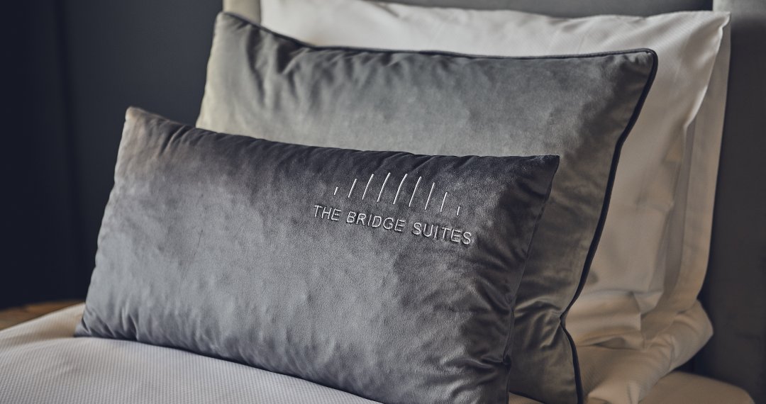 pillows with sewed logotype of the bridge suites hotel