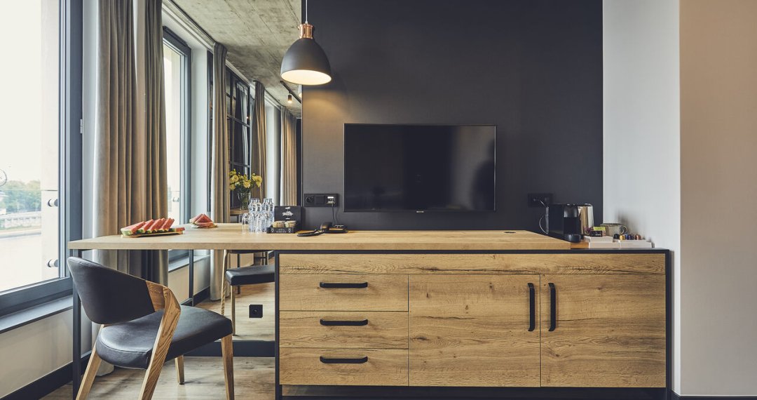 Pokój hotelowy w loftowym stylu – wysokie sufity, industrialne akcenty i nowoczesny design w standardzie 4-gwiazdkowego hotelu w Krakowie.