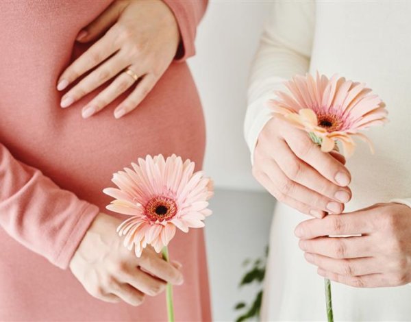 Kobiety w ciąży trzymające kwiaty