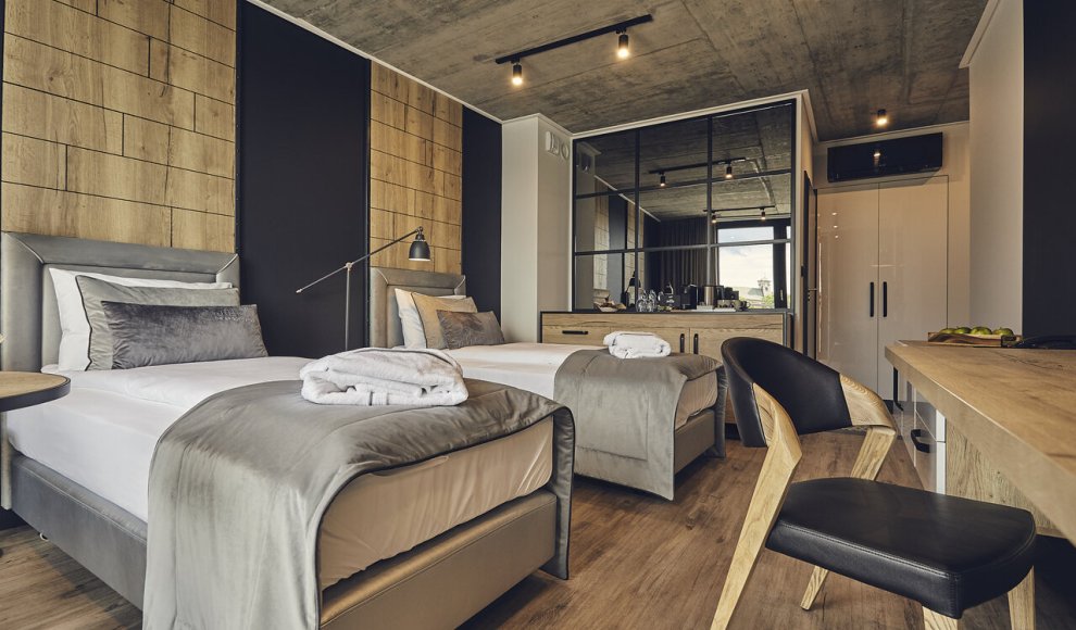 Przestronny pokój w butikowym hotelu w krakowskim Podgórzu — elegancki wystrój, komfortowe łóżko i starannie dobrane detale, stworzone z myślą o wyjątkowym wypoczynku.