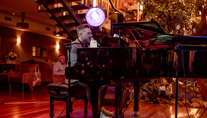 Koncert kolęd Mateusza Ziółko w lobby Hotelu Czarny Potok w Krynicy Zdrój