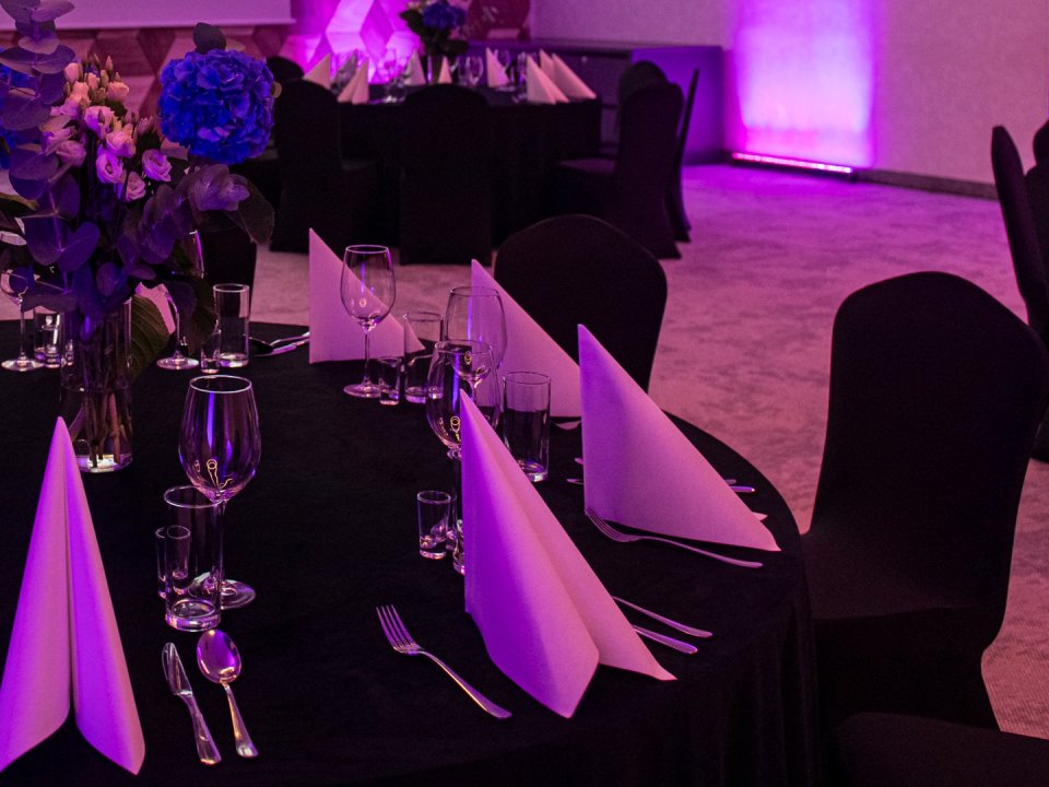 Banquet table setting at o3meet — glassware, cutlery, napkins and flowers